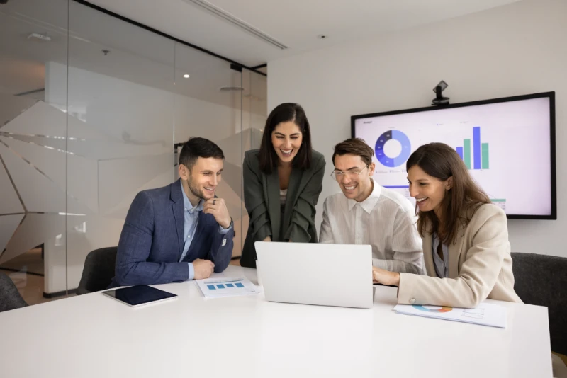 Team members reviewing data on a laptop during a collaborative meeting.